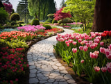 winding paved path bordered by dense flowering plants in landscaped flower garden with a winding walkway