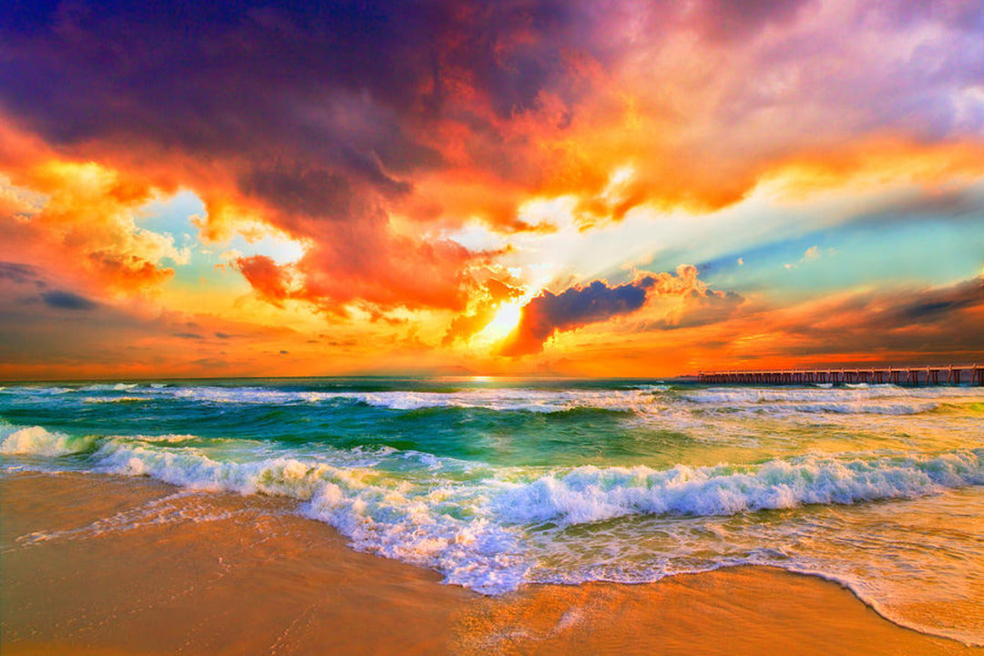 ocean shoreline beneath a cloud-filled sky waves breaking and washing onto the shore in beach